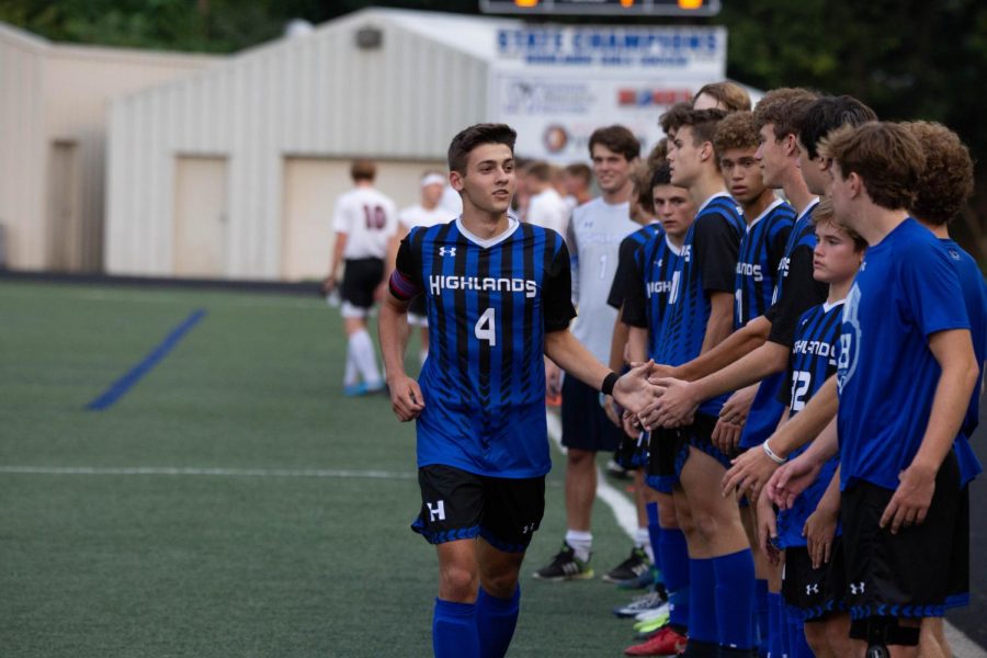 Senior Alex Ford high-fiving the soccer team before a game. 
