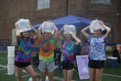 Juniors Olivia and Abby Kohler Sloan Sower and Megan Calme pose for a photo with water jugs for the Water Walk.