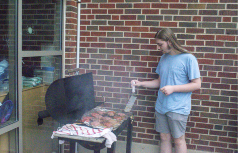 Senior Cole Wehrle prepares to flip some of the burgers.