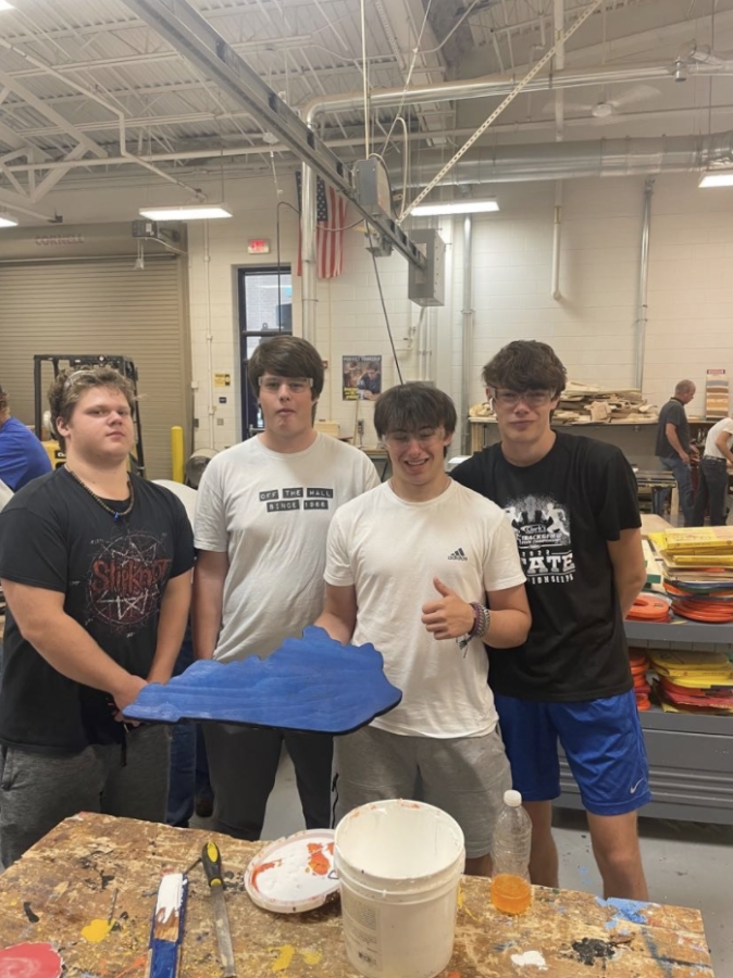 Juniors+Guerric+Naberhaus%2C+Samson+Buchanan%2C+and+Robert+Moore+with+a+classmate+holding+their+first+project+made+in+their+carpentry+class.