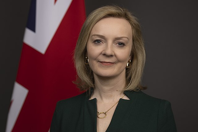 Liz Truss poses for her photo by the UK flag.