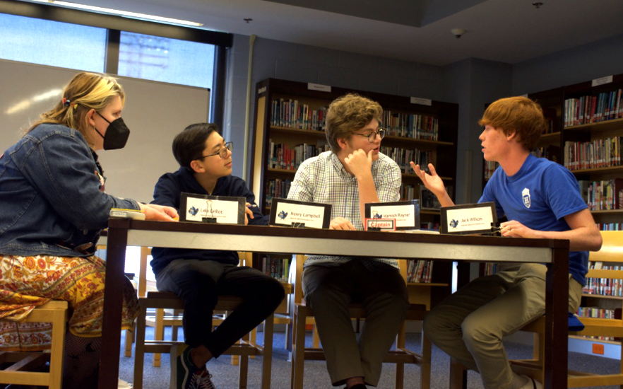 Academic team members discuss a possible answer to a bonus question. 