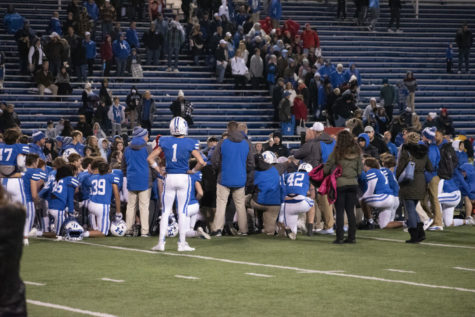 HHS Football team kneels in the huddle after losing to Scott County.