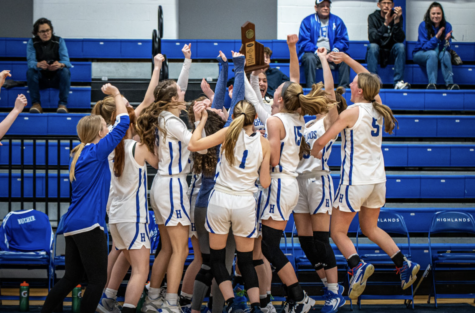 The Highlands Girls Basketball Team celebrates after the win with their trophy.