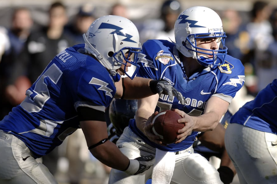 Quarterback hands the ball off to the running back, image courtesy of PxFuel.