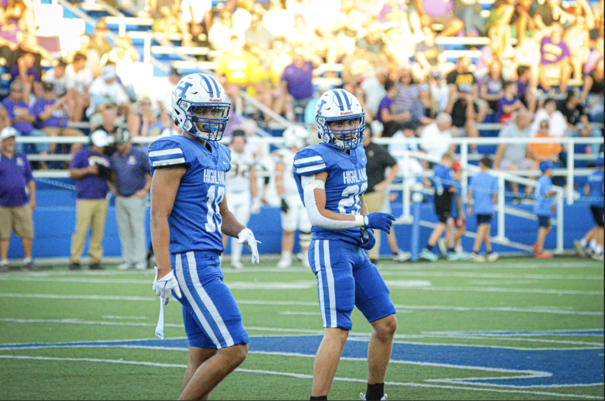 Seniors Lincoln Hicks (19) and Nate Welch (20) walk onto the field together.