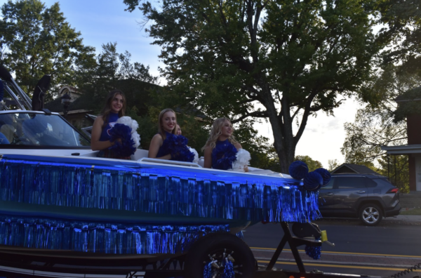 A handful of Highlands cheerleaders sit in the front of their float.