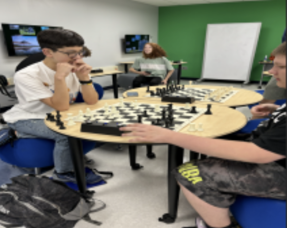 A chess match taken place during a club meeting 
