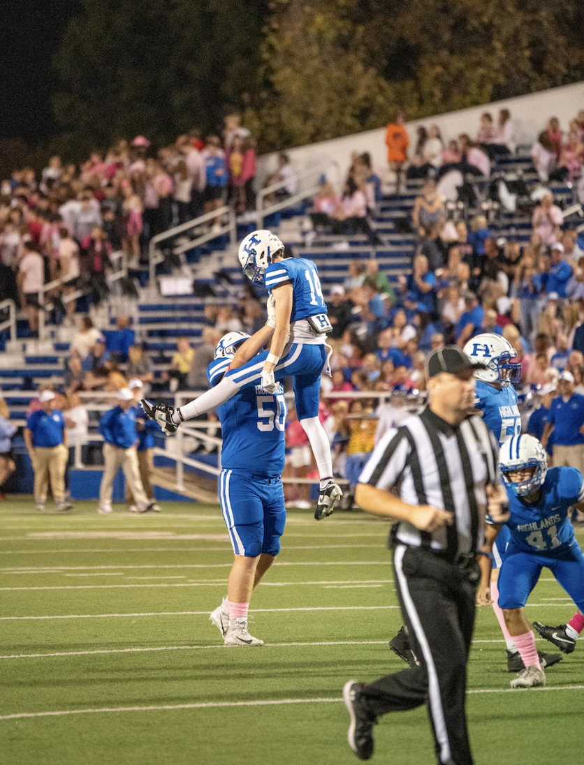 Sophomore Max Merz (50) holds up Junior Adam Surrey (14) after the touchdown.