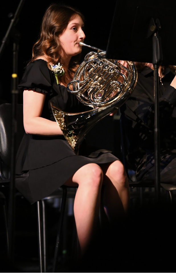Macy Laur playing her French Horn in the joint concert on February 25, 2024