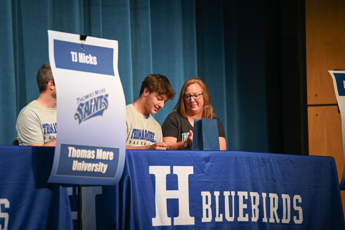 Adam Forton (12) signs his commitment to play baseball at Thomas More University.