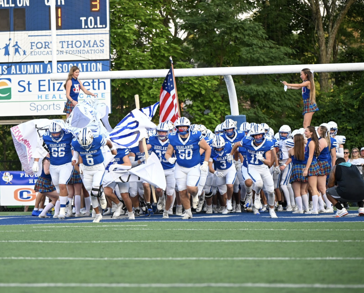 Highlands football team runs out onto the field to begin their season.