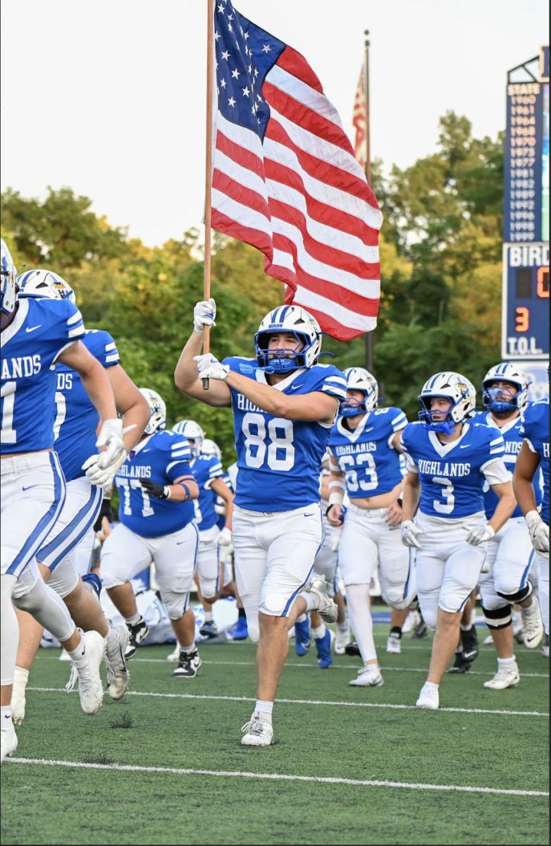 Brady Carnohan (12) starts the first run out with the American flag.