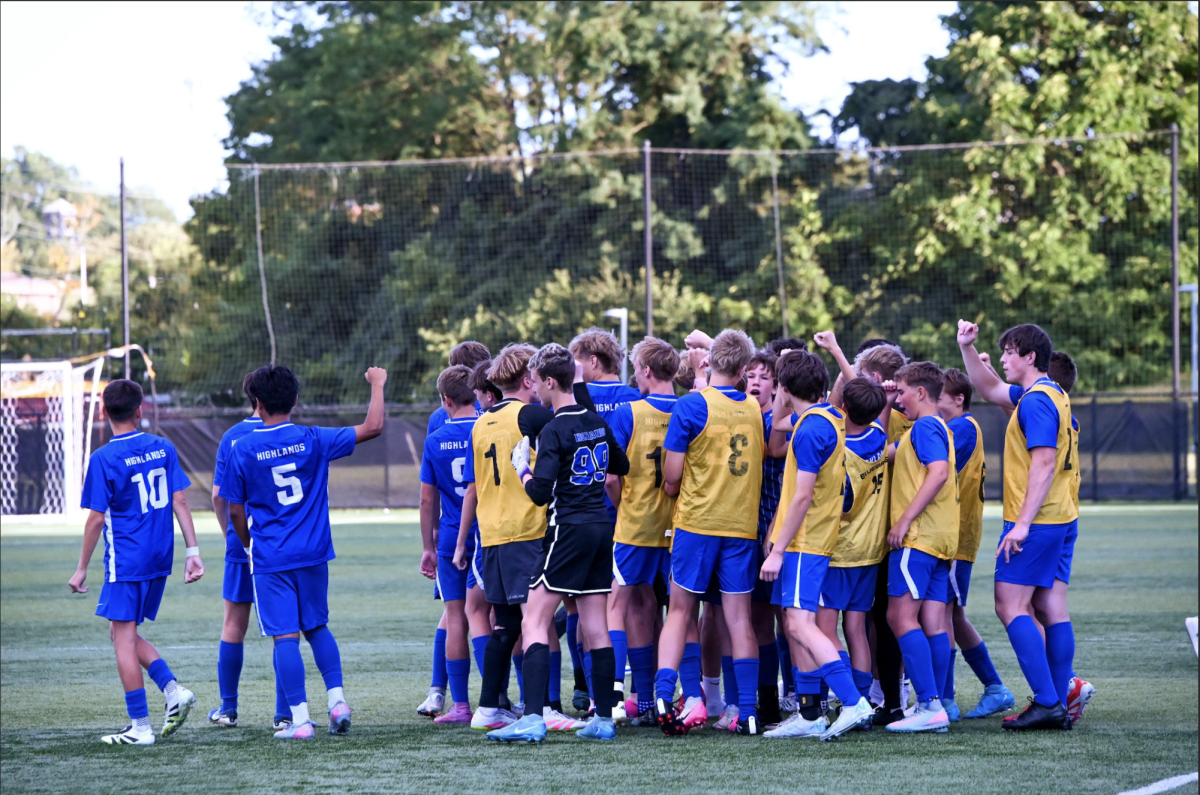 The boys varsity soccer team cheers together before the game.