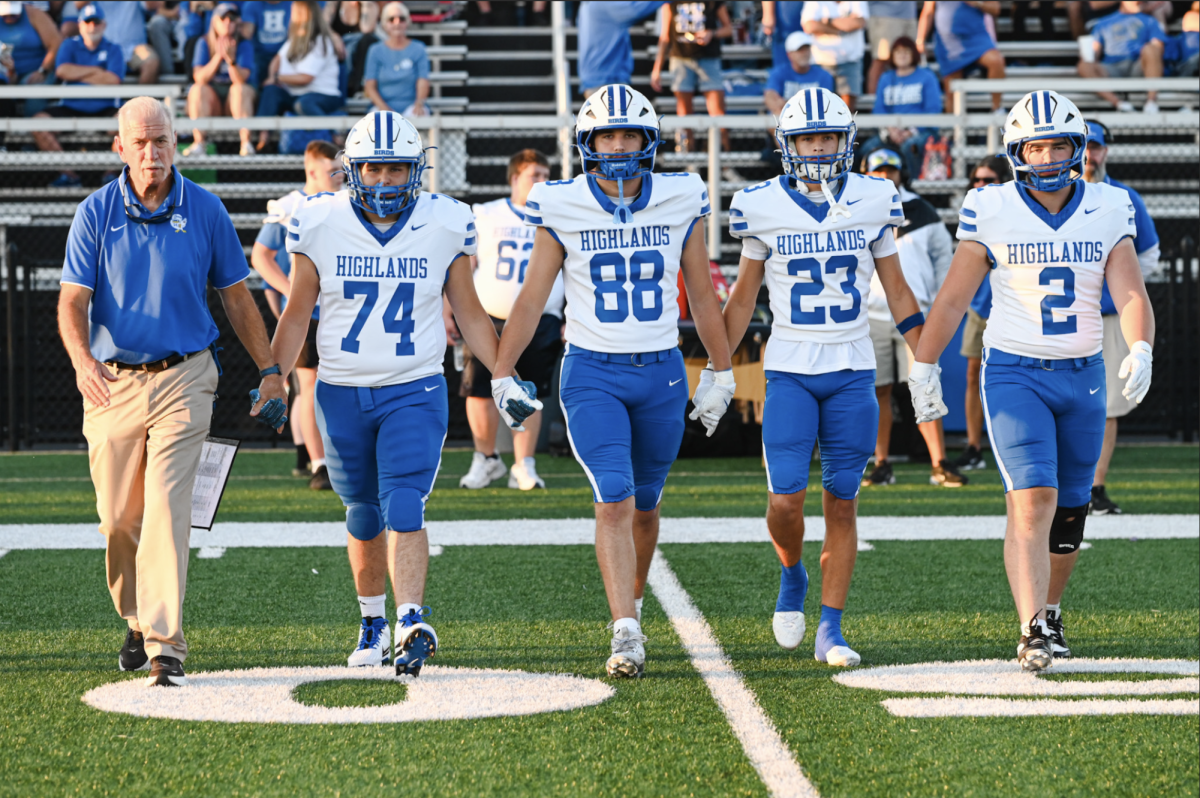 Highlands Seniors Colton Bailey, Brady Carnohan, Andrew Lucas, and Isaac Niemann walk down the field for the coin toss.