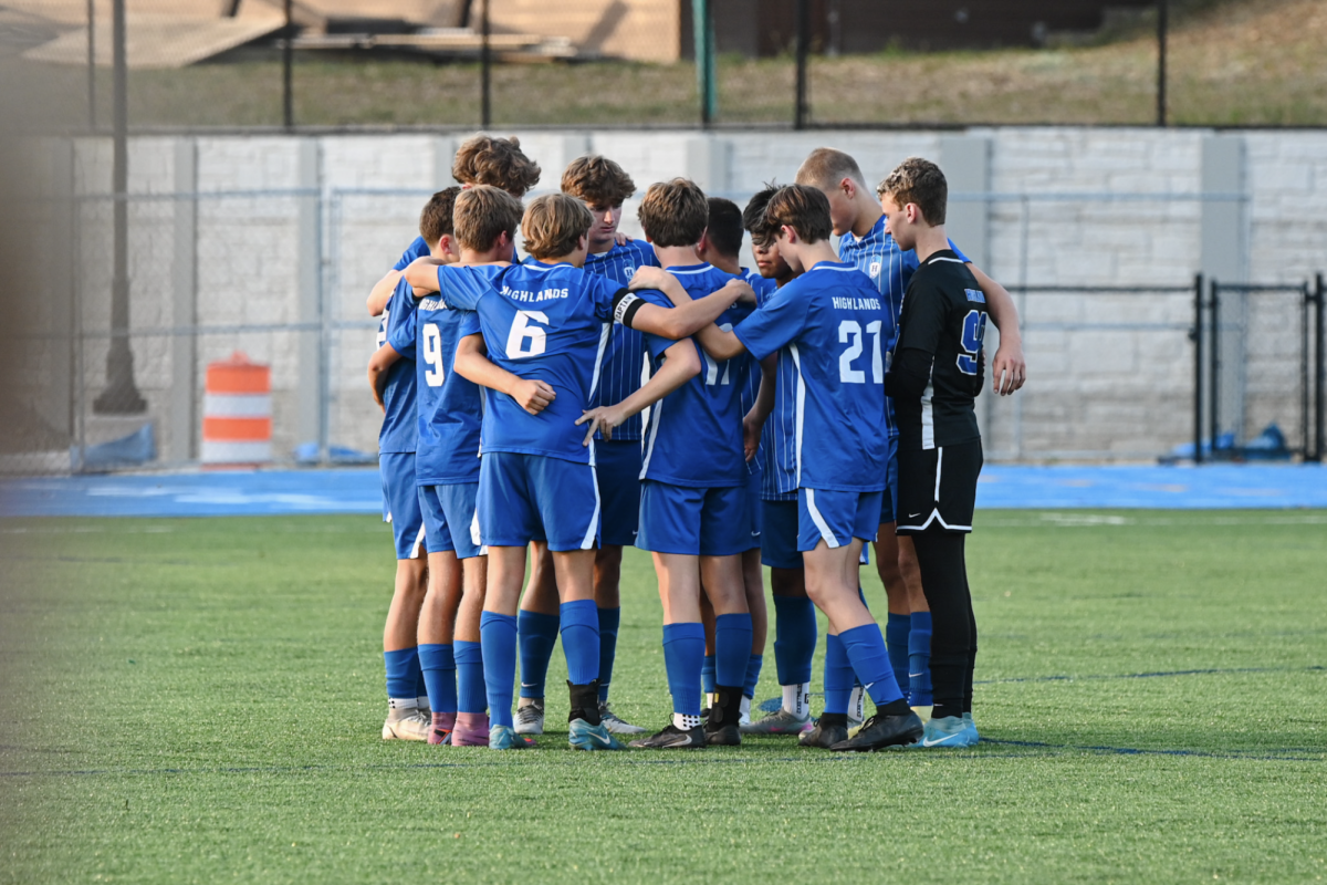 The starters for the Highlands boys soccer team huddle together before the match begins.