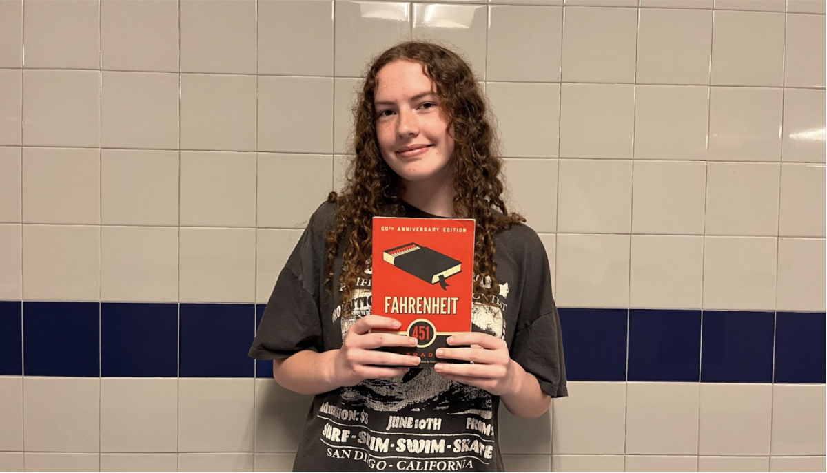 Edy Hobson poses for a photo with the book Fahrenheit 451.