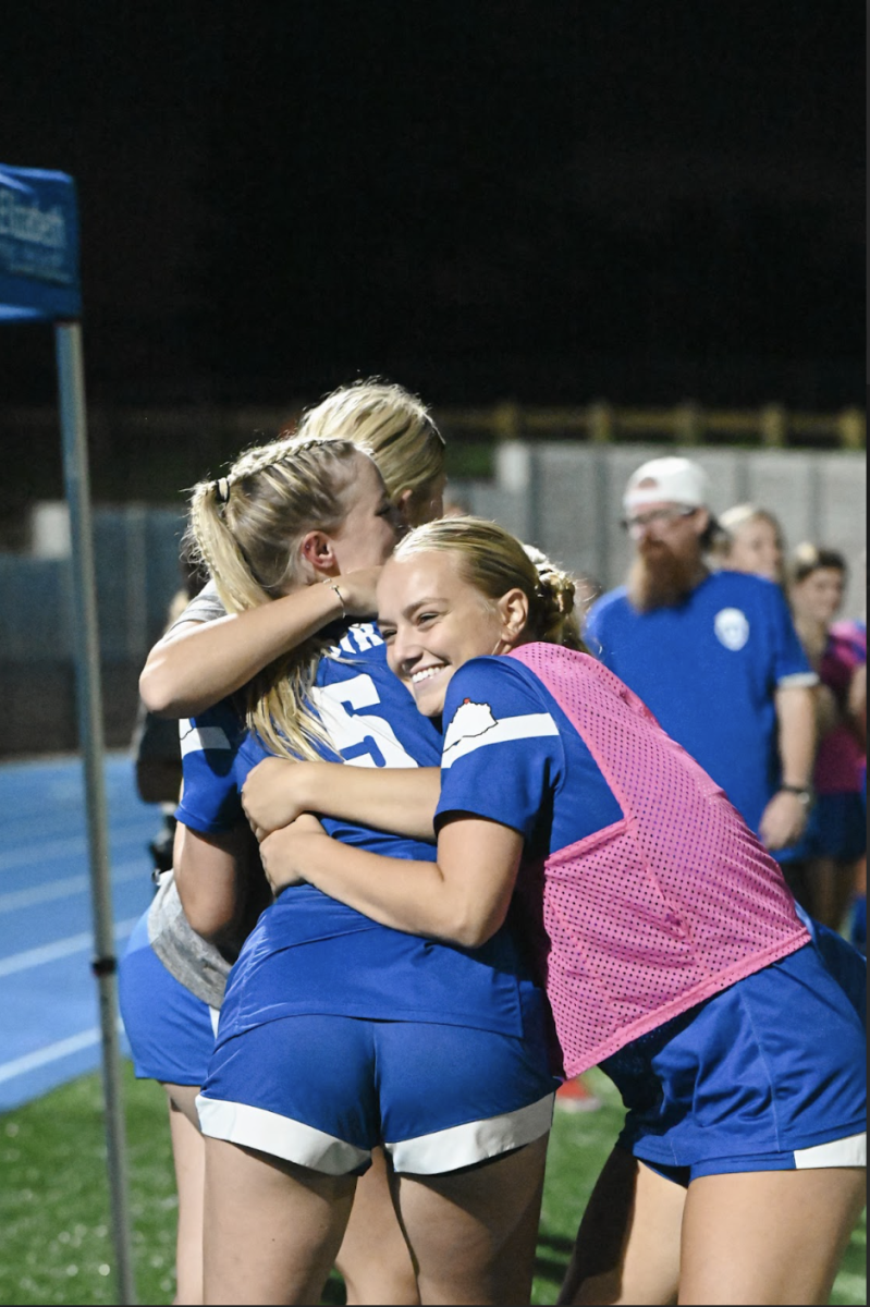 Gabby Simon (11) and Avery Schweitzer (11) hug Natalie Hinegardner (12) after her first kick in the season due to an injury.