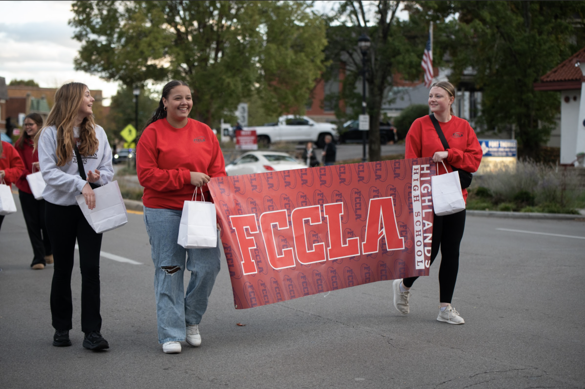 Cydni Martin (12) and Addy Eifert (12) carry the FCCLA banner during the parade.