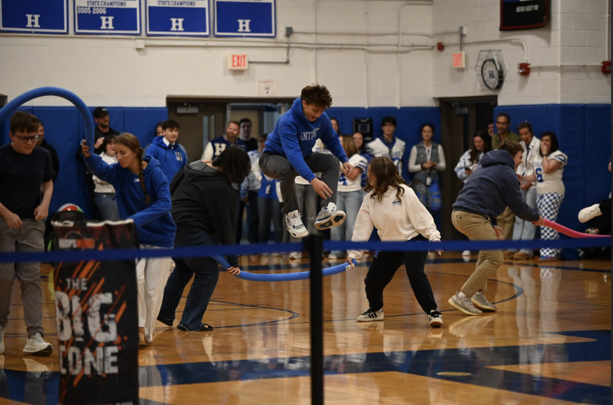 Quinton Simon (9) jumps over a pool noodle in a relay race.