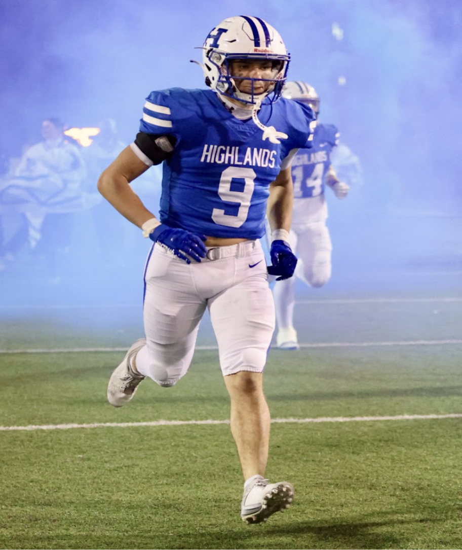 Hayden Hass ('25) runs through the opening stampede, ready to play against Collins     high school in the third round of the playoffs on Nov. 8, 2024.