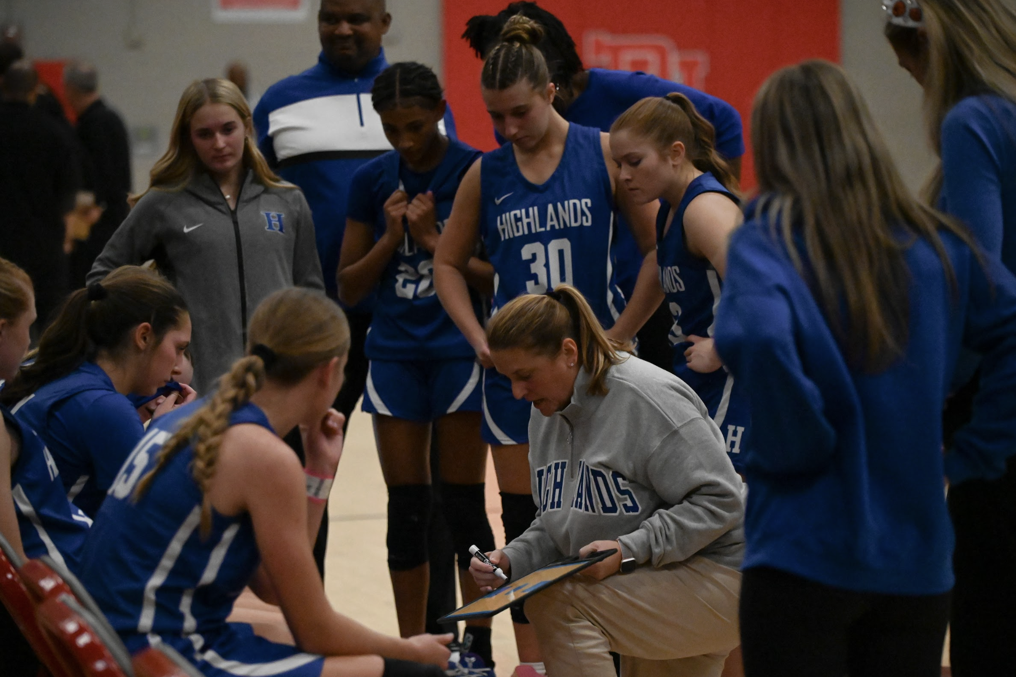 Head coach Jamie Richey goes over gameplay with the team, with Maddie Barlow (12), Avery Barber (12), Solu Nzekwu (8), Katie Bucher (12), and Gabby Neufarth (12) at the timeout. "All of us have a very strong relationship with her. She's really easy to talk to if you ever have any questions," said Barlow.