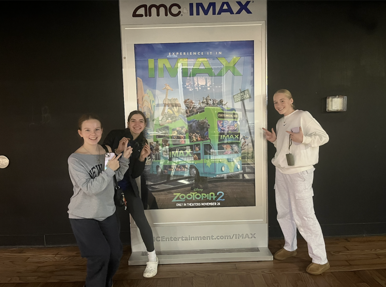 Stella Taylor (10), Caroline Palicki (10), and Betsy Krueger (10) pointing to the movie poster after watching "Zootopia 2."