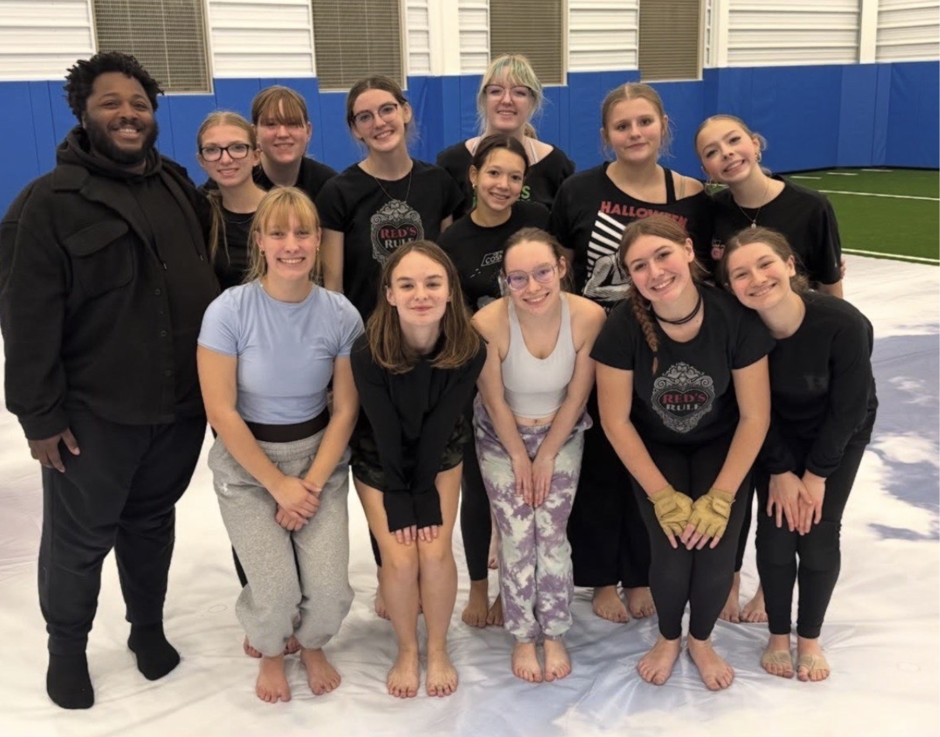 The winter guard poses with guest choreographer, Jaasiel Wilson, after practice (Courtesy of Virginia Hobson).
