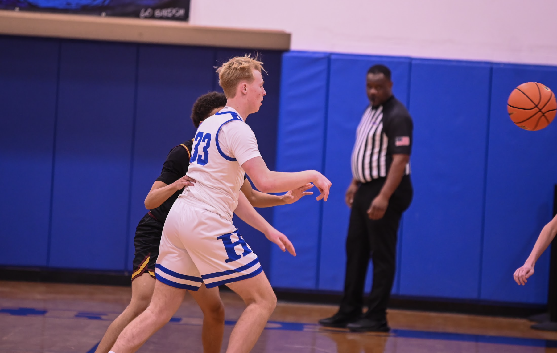 Bo Schlarman (10) throws a pass across the court to an open man. 