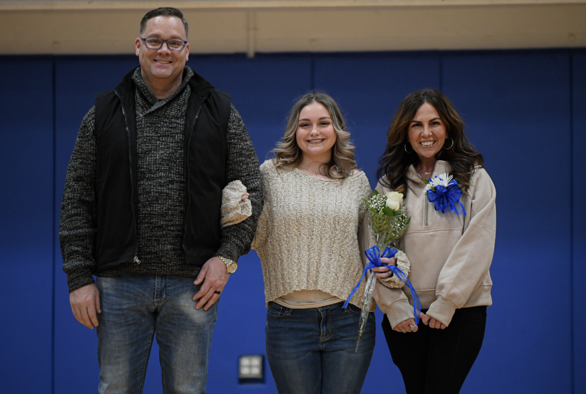 Addyson Kent (12) poses with her family during senior night.