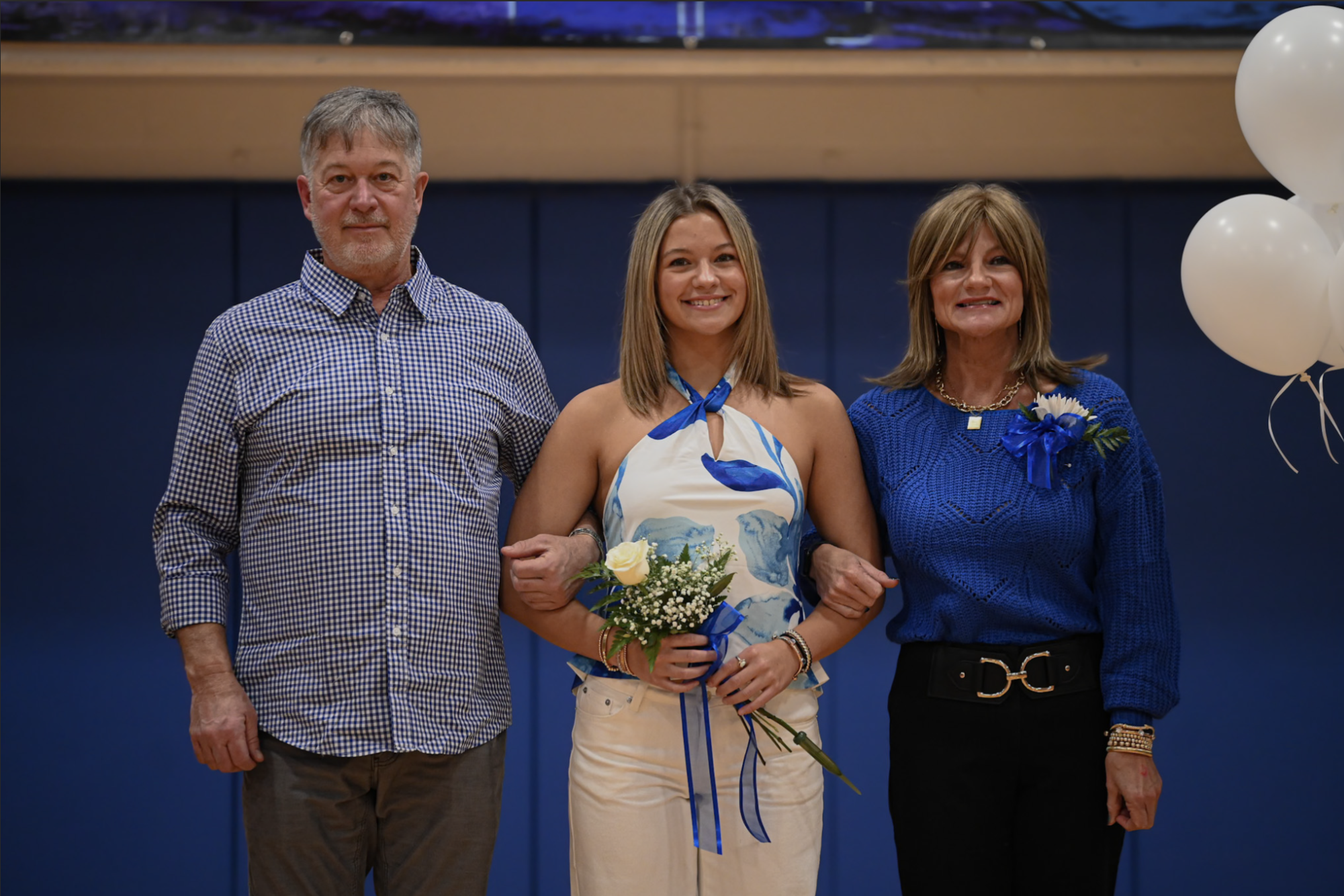 For Highlands' swim and dive senior night, Ragan Moore (12) smiles with her parents. "Senior night is so special because it is the peak of all your hard work and memories on the team," Moore said.