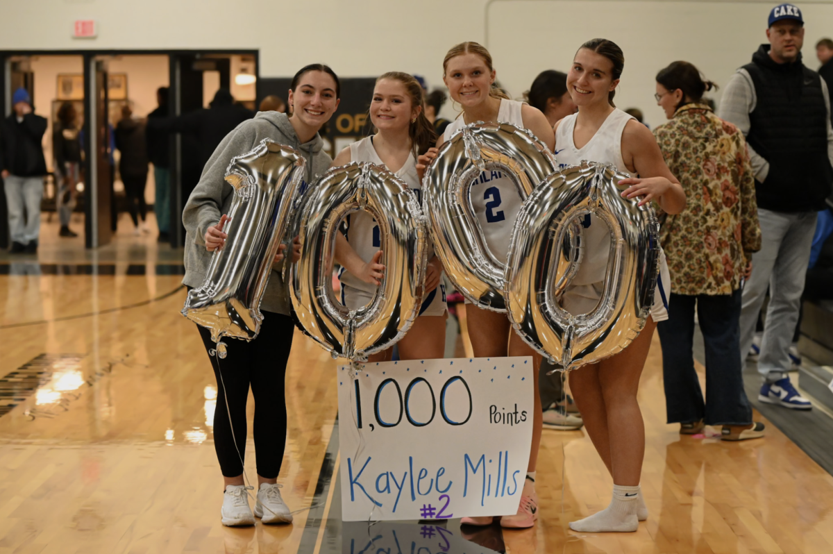 Isa Neufarth (12), Madison Barlow (12), and Avery Barber (12) celebrate Kaylee Mills (12) after she achieves 1,000 points. "Getting 1,000 points was awesome. I loved being surrounded by my family and friends when achieving this goal," Mills (12) said.