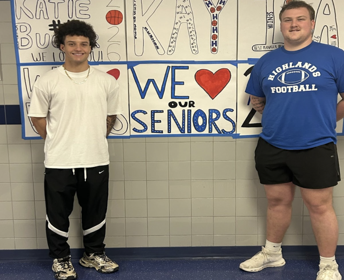 Rio Litmer (12) and Max Merz (12) stand for a photo in front of the we love our senior sign. 
