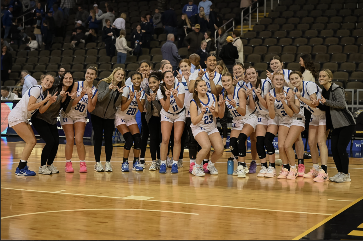 The Highlands' varsity girls basketball team hold up "W" to celebrate their win against Notre Dame in the first round of the 9th Region Tournament.
