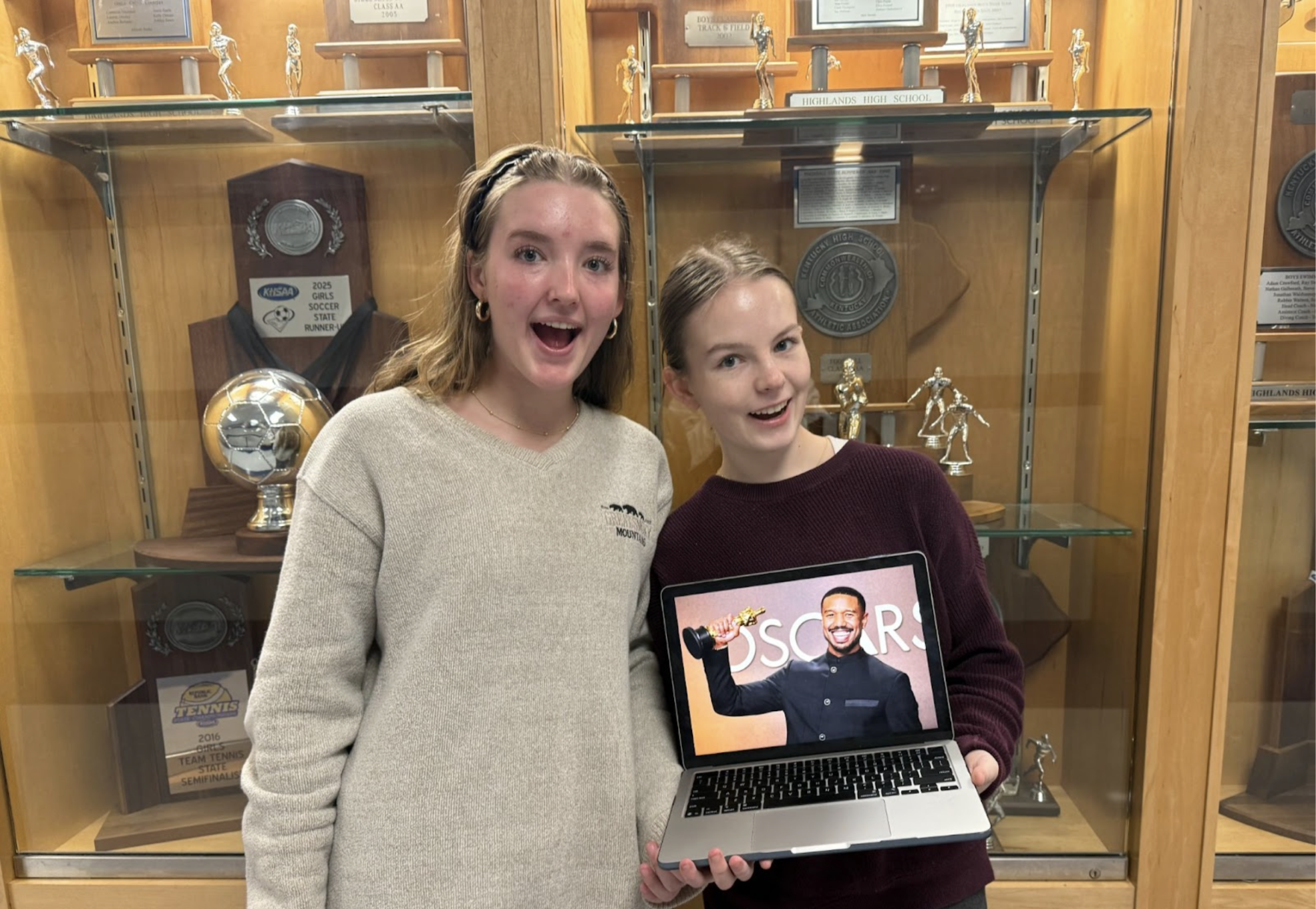 Stella Taylor (10) and Natalie Abdon (10) pose with a photo of Michael B. Jordan winning his Oscar. 