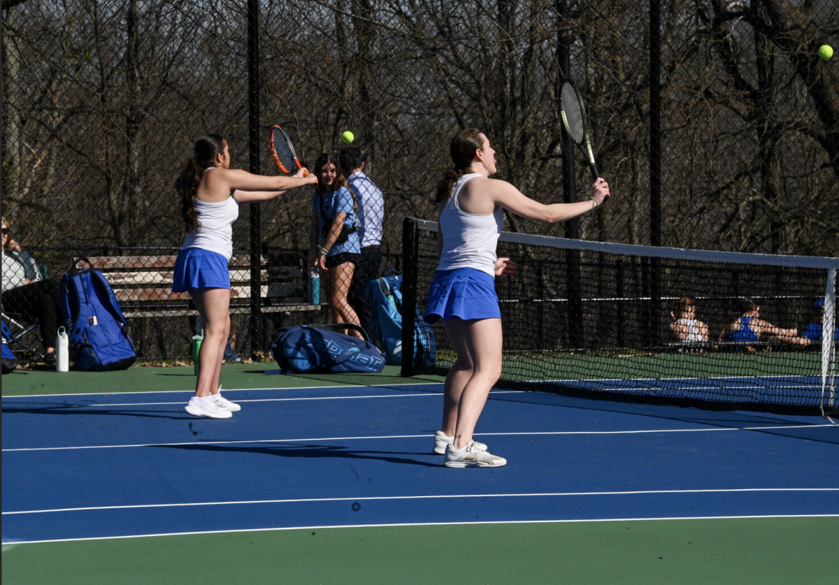 Sydney Lehmann (12) and Ava Muzumdar (12) warm up before there double match. "We know what we need to work on, but overall it was a great first show and we are exited for the future," Lehmann (12) said.
