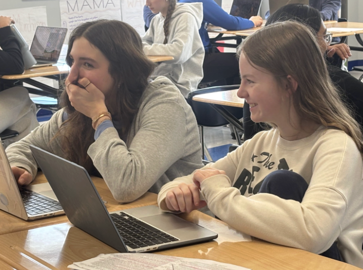 Caroline Palicki (10) and Stella Taylor (10) share a laugh during class
