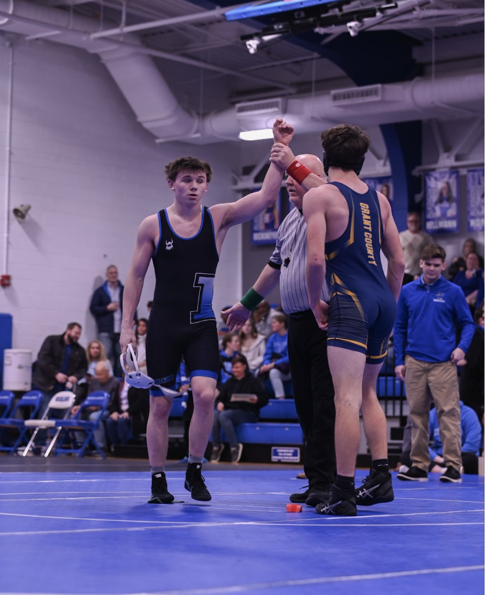Kayson White (10) getting his hand raised after winning his match.
