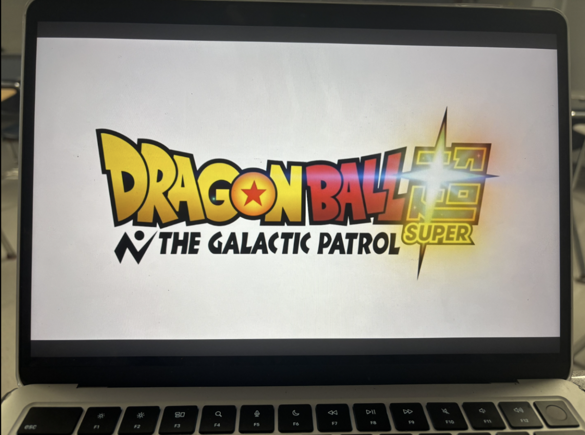 A MacBook screen shows the announcement trailer for Dragon Ball Super: Galactic Patrol.