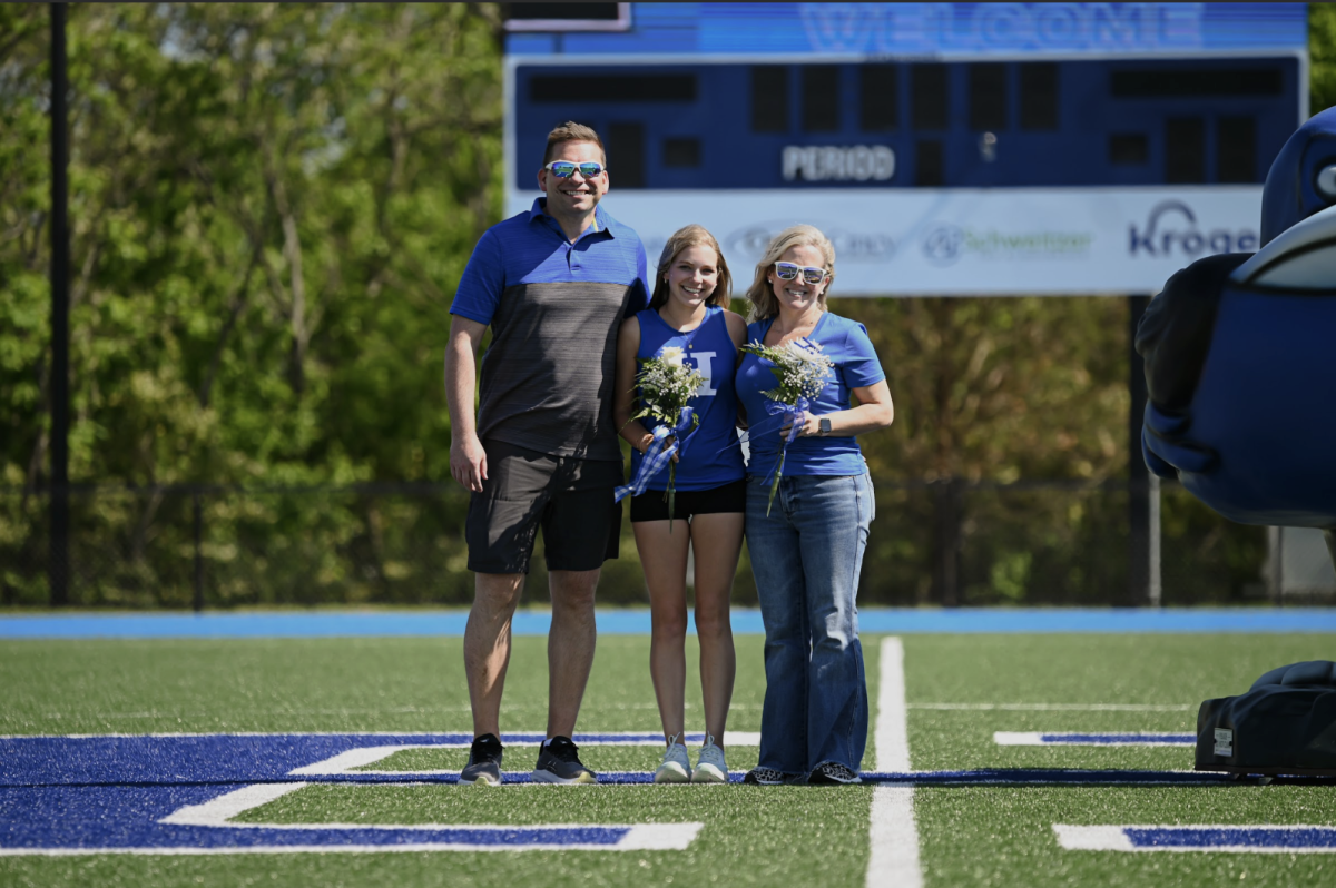 Aubrey Cleves (12) celebrates senior night next to her parents. "My favorite part about track is the frienships I have made and being part of a team that makes a sport so fun," Cleves (12) said.