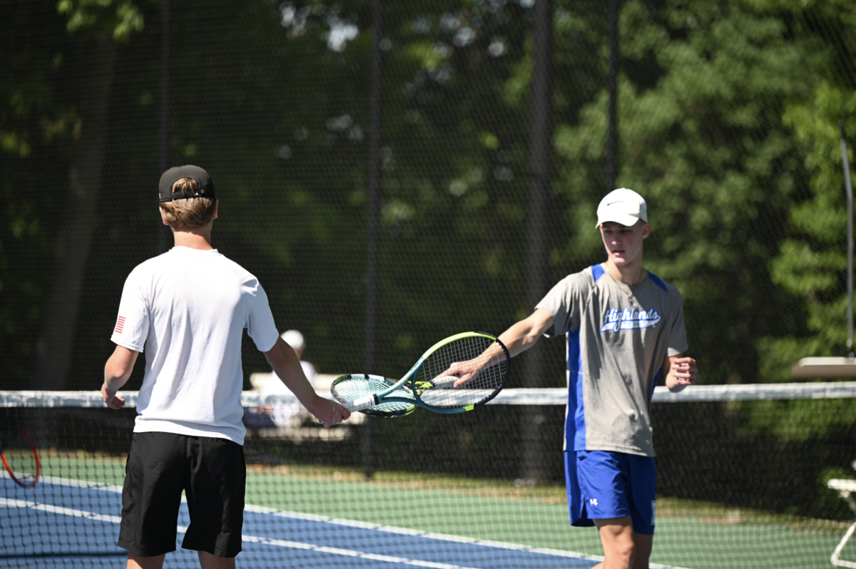Players Daniel Beasey (12) and Haydon Newton (12) tap rackets after a successful point.