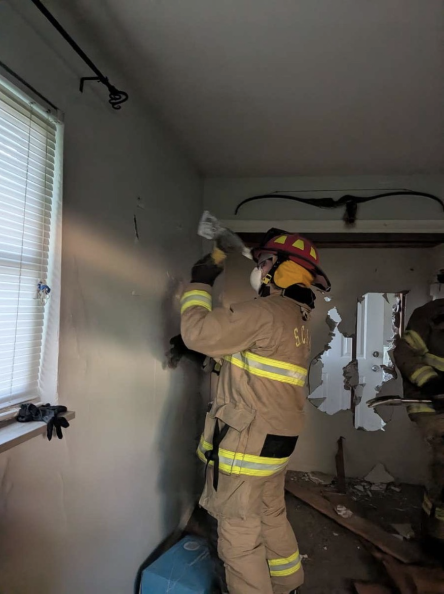 Caleb Hudson (12) using an axe to tear down a wall during training at Station 12 with Campbell Fire Rescue (Courtesy of Caleb Hudson).